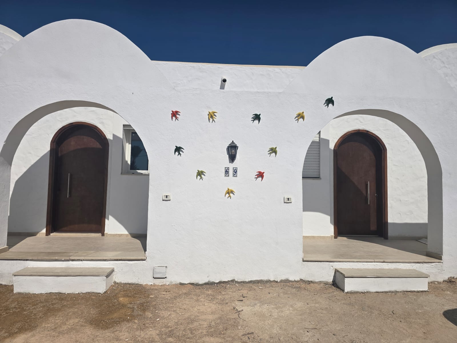 Façade des deux villas jumelles, chacune avec sa propre porte d'entrée voûtée